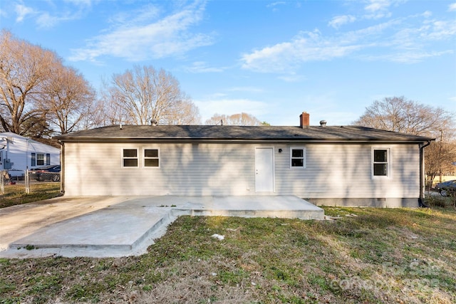 back of property with a yard, fence, and a patio