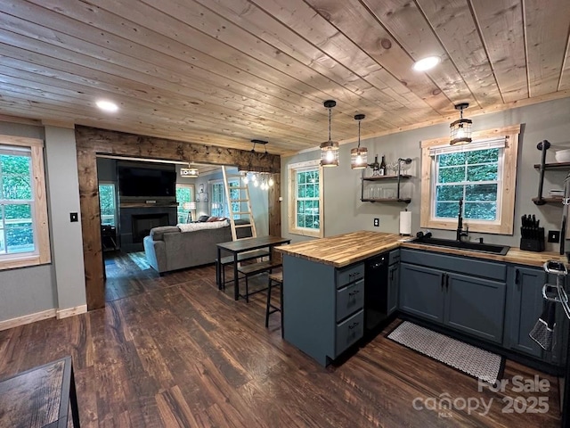 kitchen with dark wood-style floors, a sink, wood counters, wooden ceiling, and a peninsula