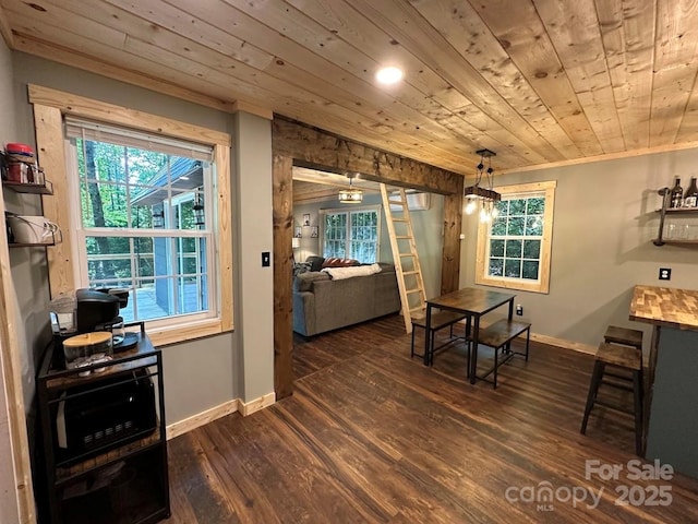 dining room featuring wooden ceiling, baseboards, dark wood finished floors, and crown molding