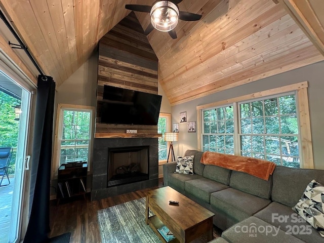 living room featuring lofted ceiling, ceiling fan, a tile fireplace, wood finished floors, and wood ceiling