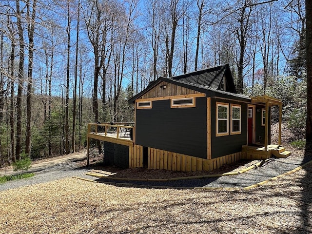 view of property exterior featuring board and batten siding and a wooden deck