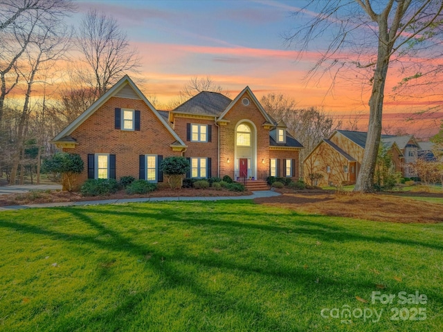 colonial home with a front yard and brick siding