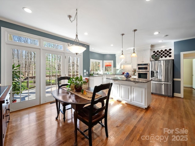 dining space featuring ornamental molding, recessed lighting, baseboards, and wood finished floors