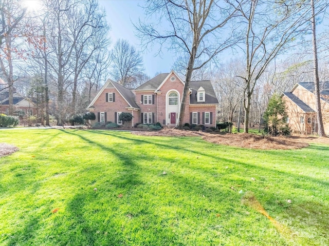 view of front of house with a front lawn and brick siding