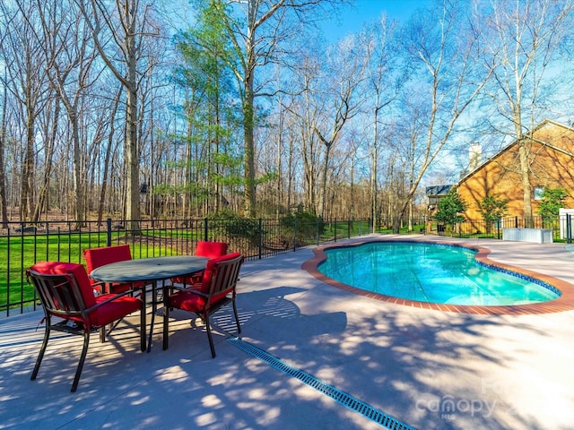 view of swimming pool featuring fence, outdoor dining area, a fenced in pool, and a patio