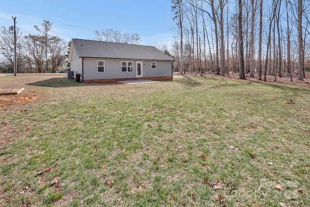 exterior space with a yard, a shingled roof, central AC, and a patio