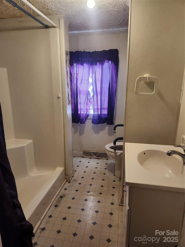 bathroom with toilet, walk in shower, a textured ceiling, and vanity