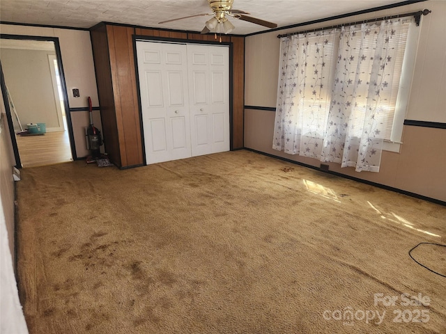 unfurnished bedroom with carpet floors, ornamental molding, and a closet