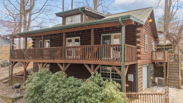 rear view of property featuring metal roof, stairway, and log siding