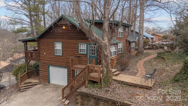 back of house featuring driveway, stairway, and an attached garage