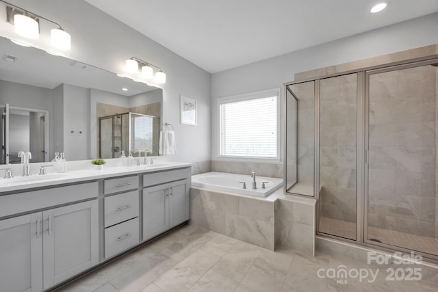 bathroom with a bath, a shower stall, double vanity, and a sink
