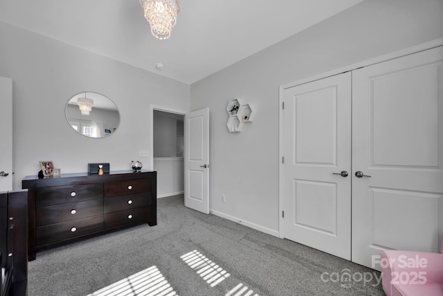 bedroom featuring baseboards, an inviting chandelier, carpet flooring, and a closet