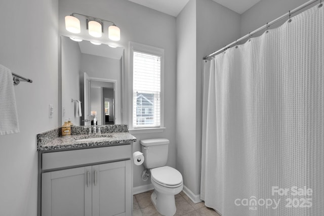 full bathroom with tile patterned floors, a healthy amount of sunlight, vanity, and toilet