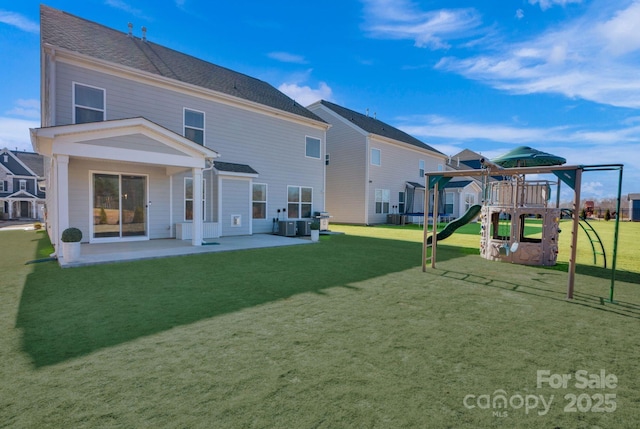 rear view of property with a lawn, a patio, and playground community