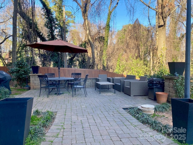 view of patio featuring fence, outdoor dining area, area for grilling, and an outdoor living space