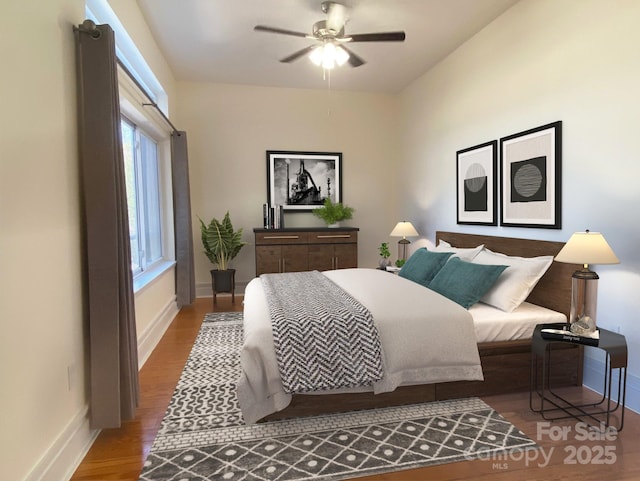 bedroom featuring ceiling fan, baseboards, and wood finished floors