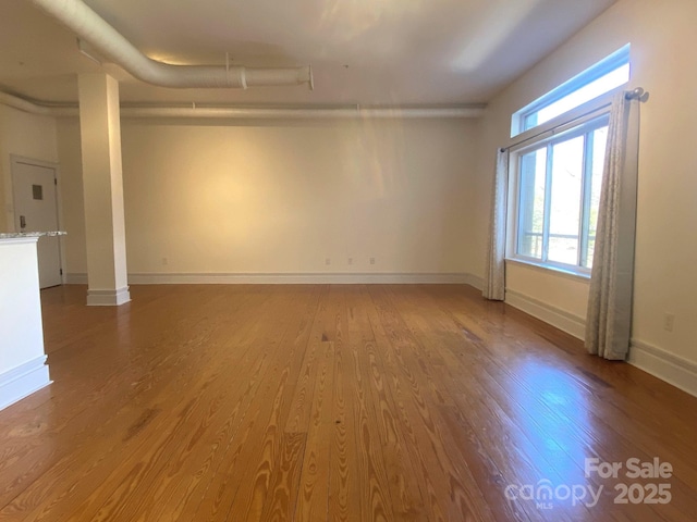 empty room featuring wood finished floors and baseboards