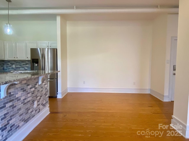 interior space featuring light wood-type flooring and baseboards