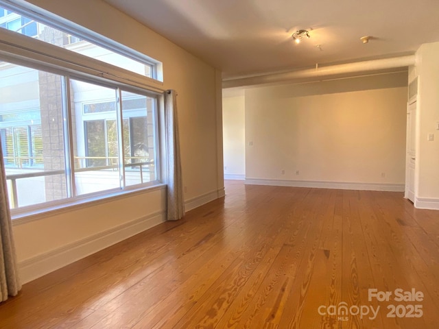 spare room with light wood-style flooring and baseboards