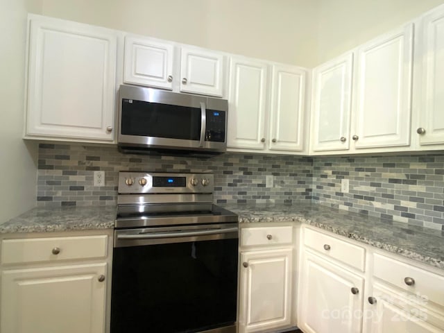 404 N Laurel Ave Unit 28, Charlotte, NC 28204 - kitchen featuring white cabinets, appliances with stainless steel finishes, light stone countertops, and backsplash