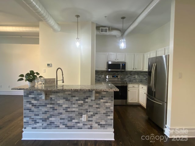 404 N Laurel Ave Unit 28, Charlotte, NC 28204 - kitchen with stone counters, a breakfast bar, visible vents, white cabinetry, and stainless steel appliances