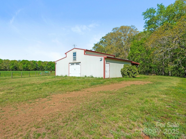 view of pole building with a lawn and fence