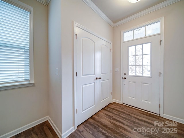 foyer entrance with dark wood-style floors, ornamental molding, and baseboards