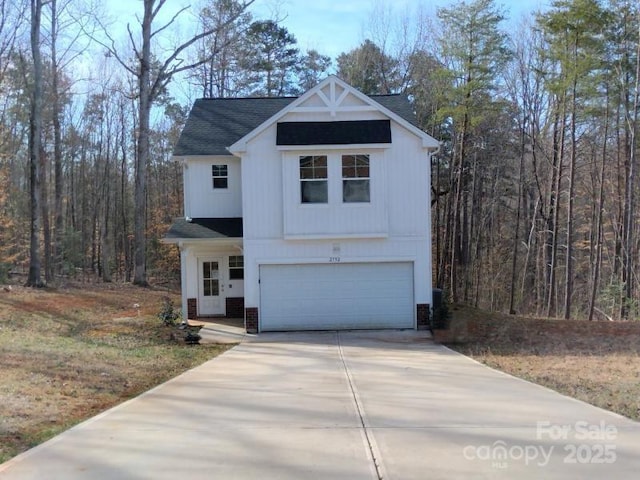 modern farmhouse style home featuring a garage, brick siding, driveway, and a view of trees