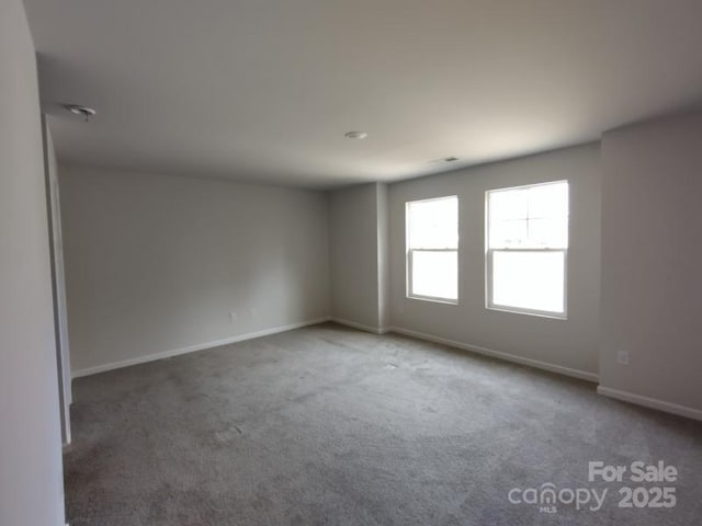 carpeted spare room with baseboards