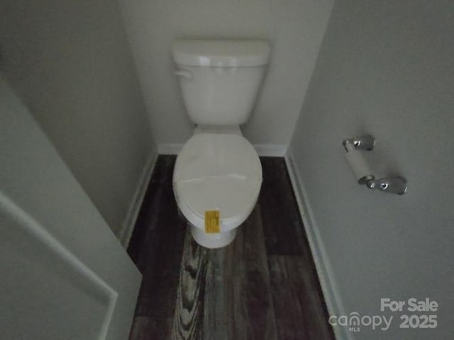 bathroom featuring baseboards, toilet, and wood finished floors