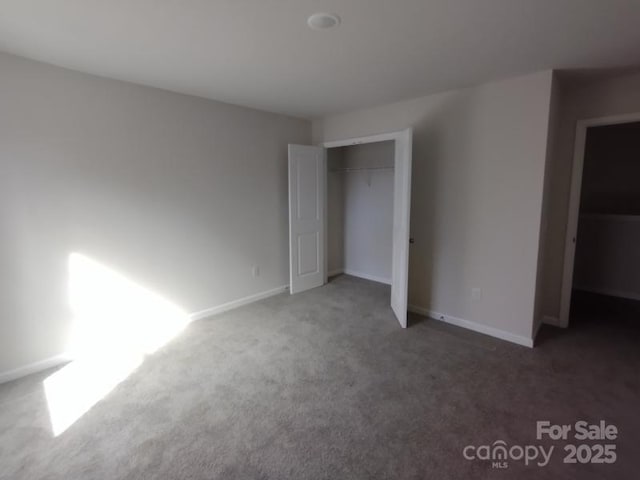 unfurnished bedroom with carpet floors, a closet, and baseboards