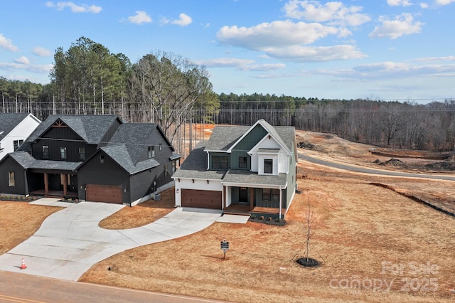 view of front of house with a porch, driveway, a shingled roof, and fence