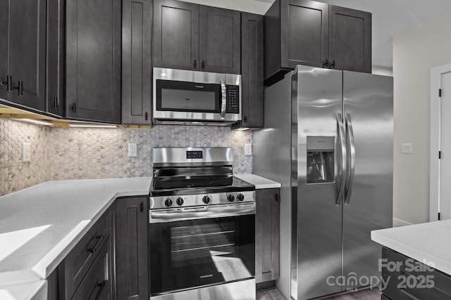 kitchen with appliances with stainless steel finishes, light countertops, and backsplash