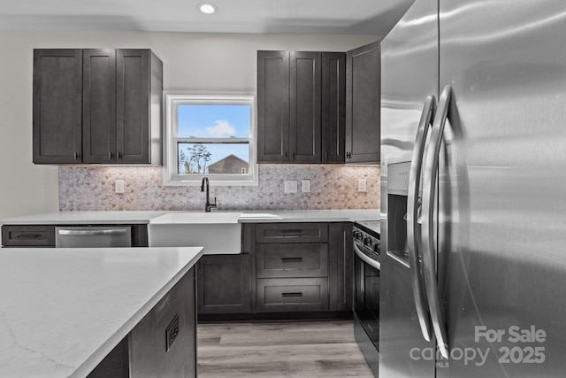 kitchen featuring appliances with stainless steel finishes, light countertops, and backsplash