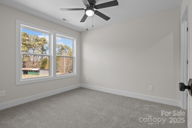 carpeted spare room featuring visible vents, ceiling fan, and baseboards