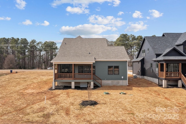 rear view of property with a shingled roof