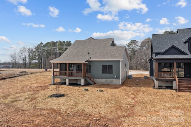 back of house featuring roof with shingles, stairway, and a wooden deck