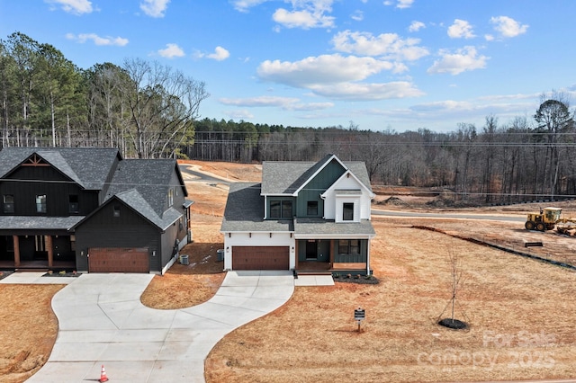 view of front of house with a garage, covered porch, driveway, and roof with shingles