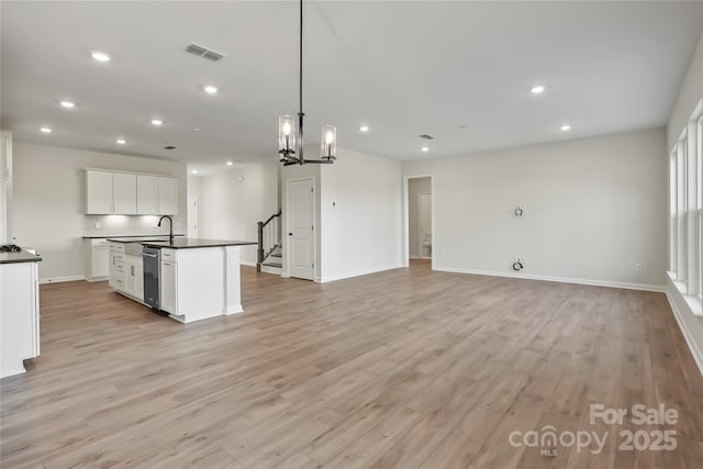 kitchen featuring dark countertops, recessed lighting, visible vents, light wood-style flooring, and white cabinetry