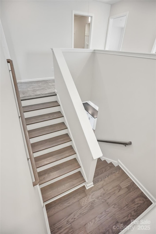 stairs with wood finished floors and baseboards