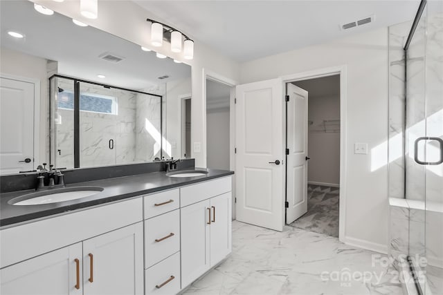 bathroom featuring marble finish floor, a marble finish shower, a sink, and visible vents