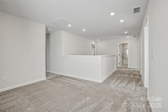 empty room with baseboards, recessed lighting, visible vents, and light colored carpet