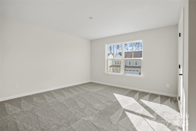 carpeted empty room with baseboards