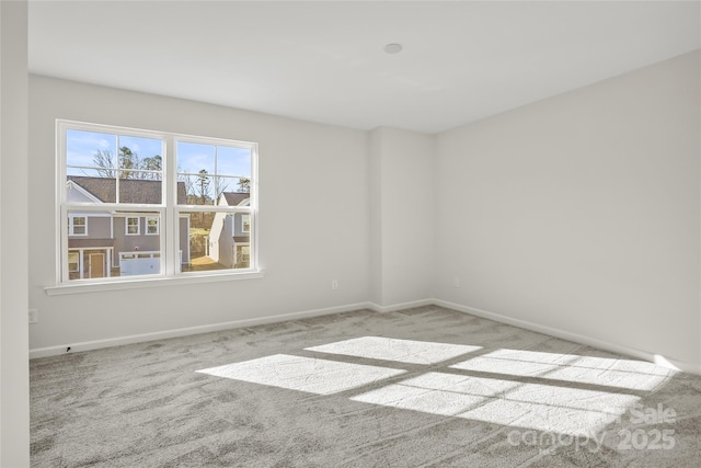 carpeted empty room featuring baseboards