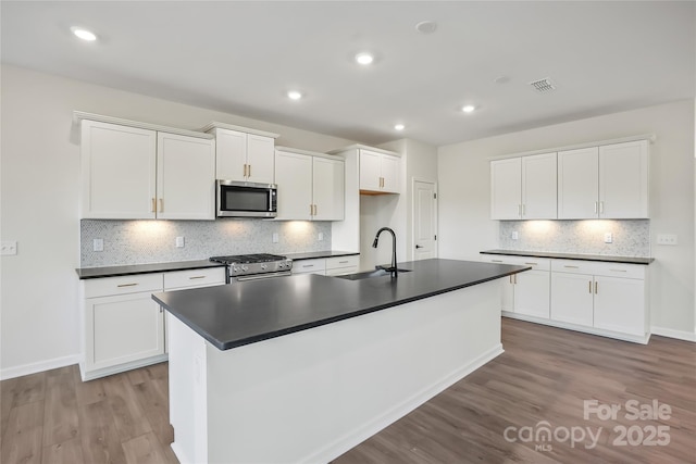 13729 Roderick Dr Unit 188, Huntersville, NC 28078 - kitchen featuring white cabinetry, dark countertops, appliances with stainless steel finishes, light wood finished floors, and a sink