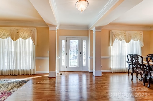 foyer entrance featuring plenty of natural light, decorative columns, and wood finished floors