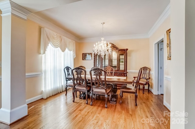 dining area featuring a chandelier, baseboards, light wood-type flooring, decorative columns, and crown molding