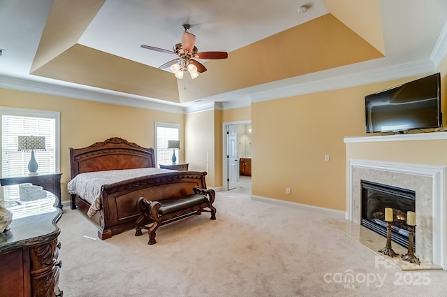 bedroom featuring a tray ceiling, carpet, a fireplace, crown molding, and baseboards