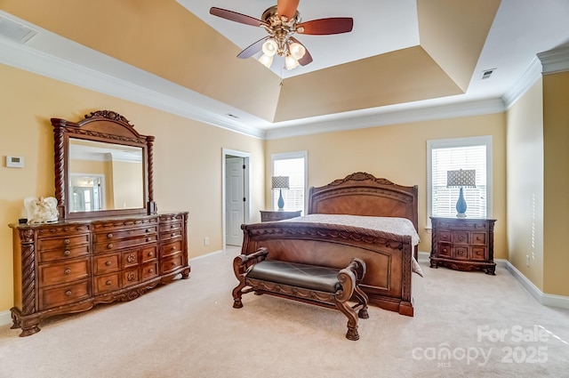 bedroom featuring carpet floors, a tray ceiling, crown molding, visible vents, and baseboards