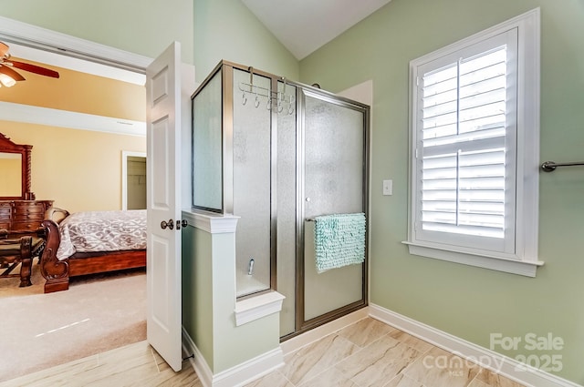 full bathroom featuring ensuite bathroom, a ceiling fan, a stall shower, vaulted ceiling, and baseboards